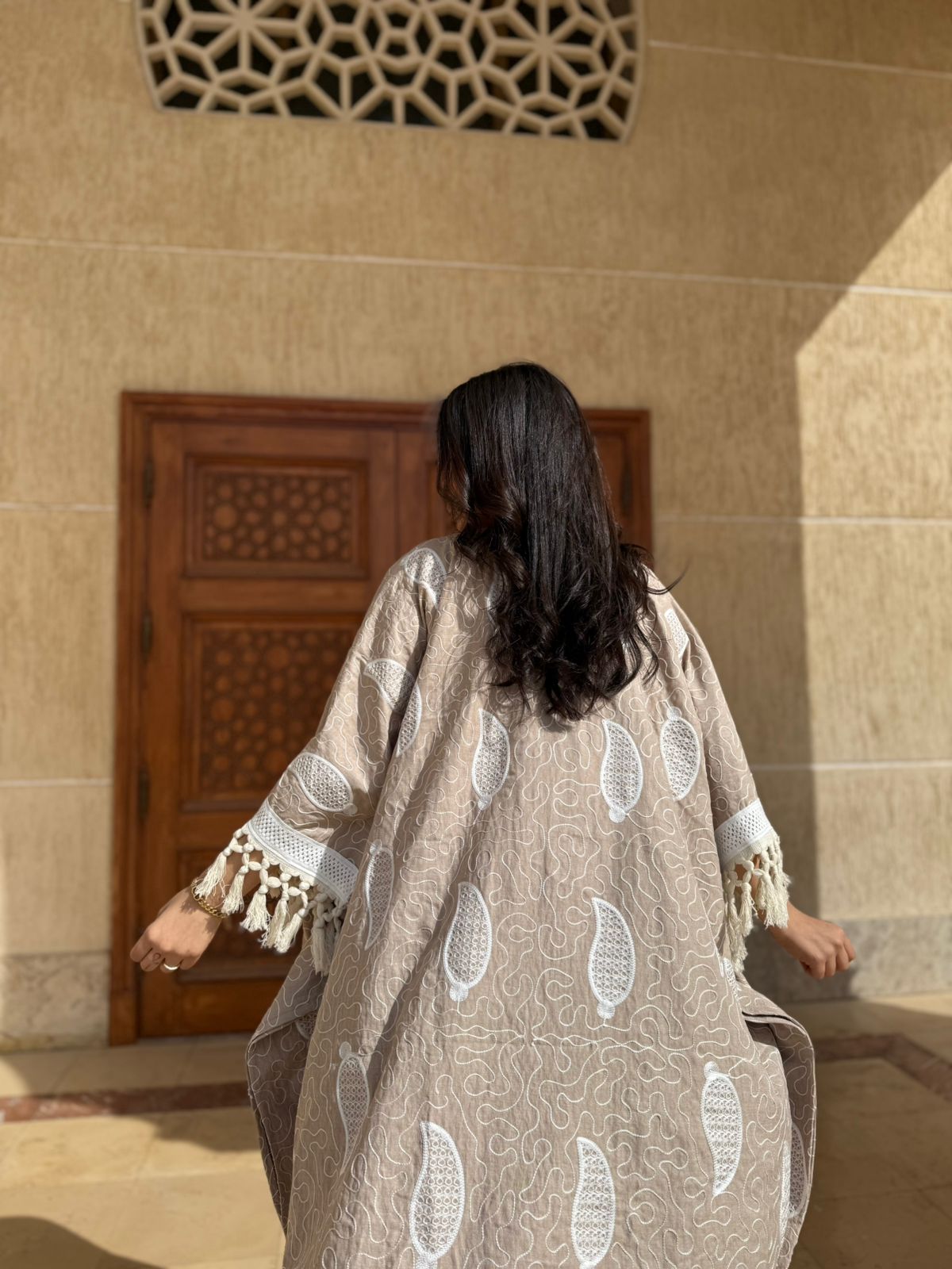 قفطان بوهيمي باللون الرملي مع تطريز أبيض وشراشيب عريضة