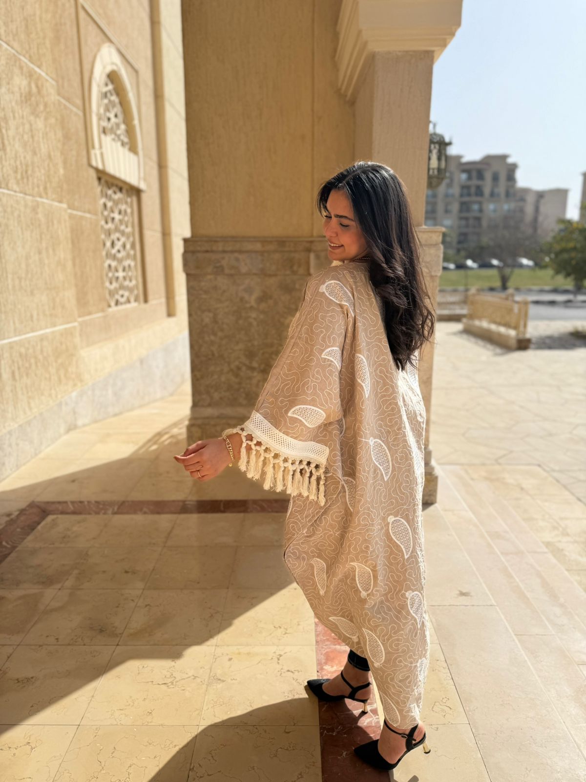 قفطان بوهيمي باللون الرملي مع تطريز أبيض وشراشيب عريضة