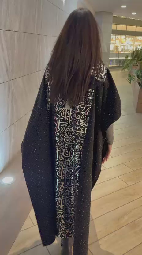 كيب/عباية "حروف" السوداء بتصميم الخط العربي